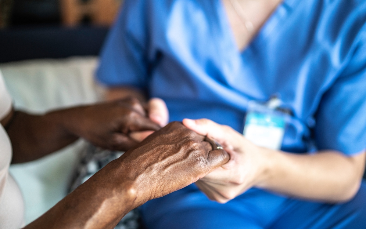 Nurse holding hands with patient