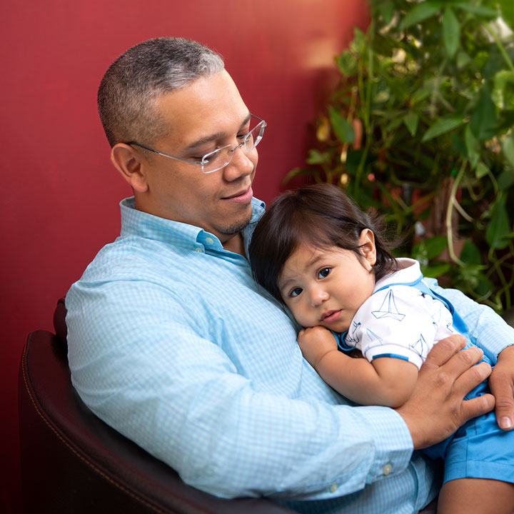 man with blue shirt holding his child 