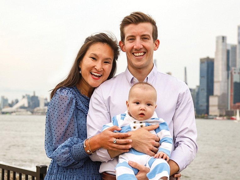 A male/female couple and an infant with skyline in the background