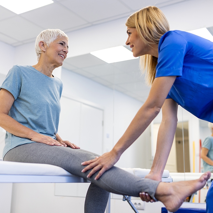 older woman working with physical therapist