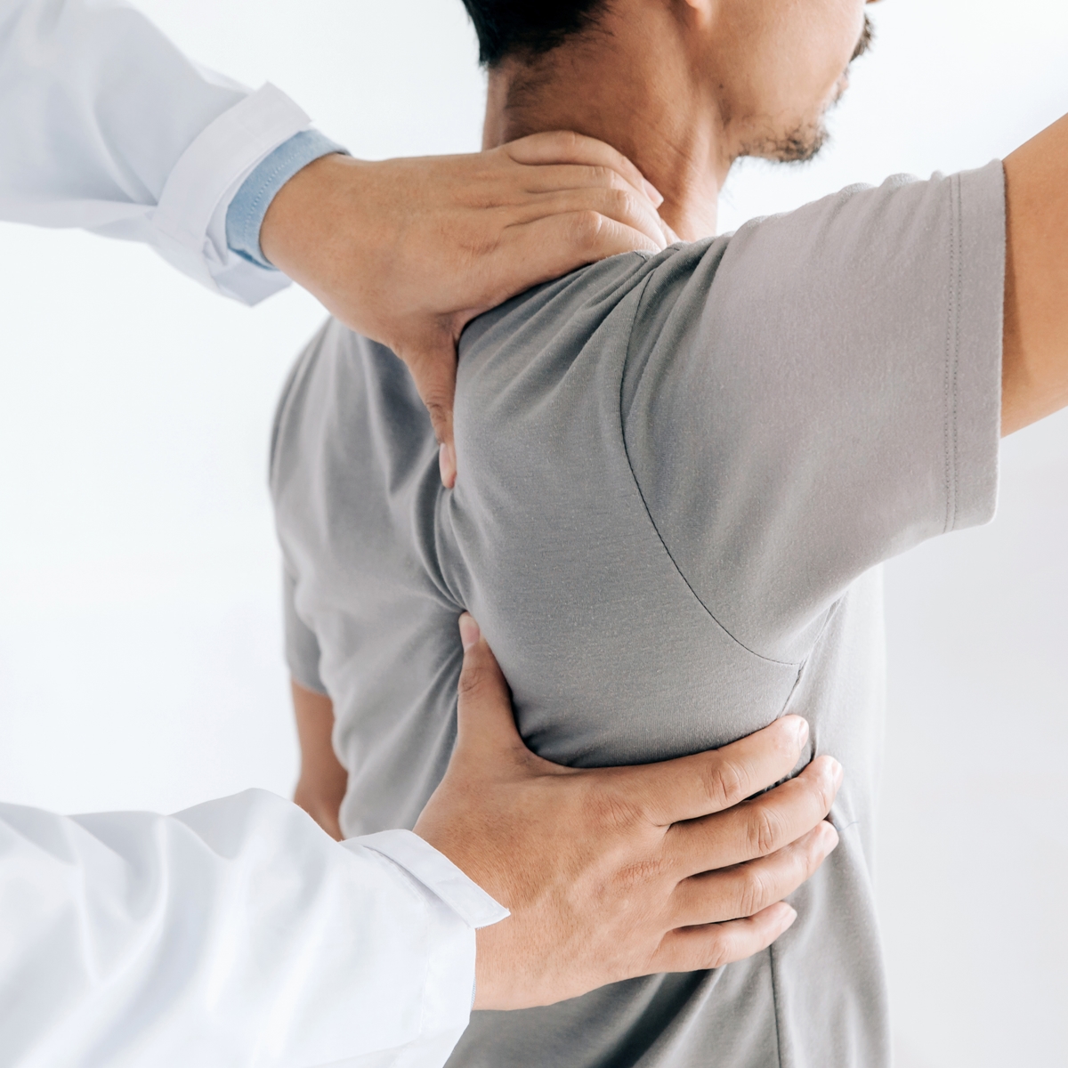 Doctor examening man's shoulder